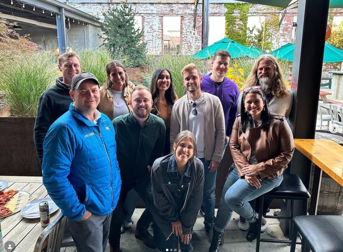 The Ample team gathered on a patio at an outdoor bar